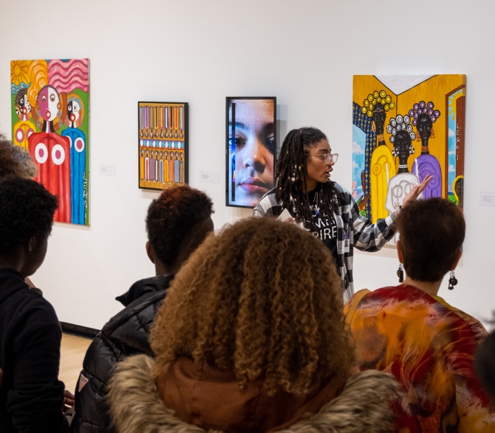 Curator Tiffany Gaines explaining the exibition to a group of patrons