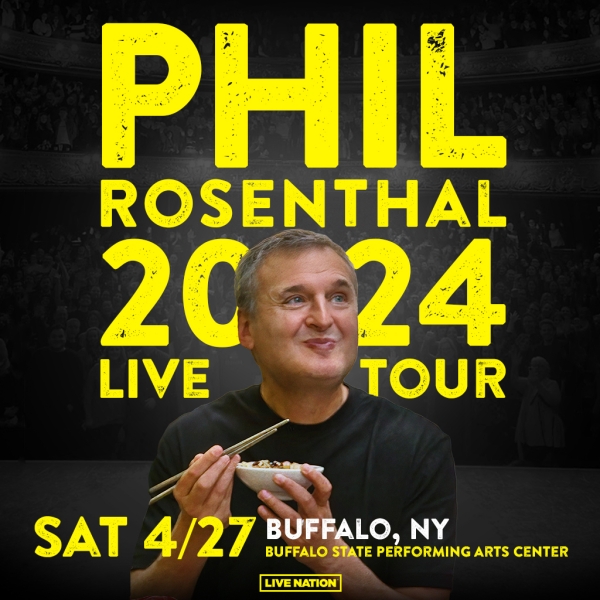 Phil Rosenthal smiling and eating with chopsticks