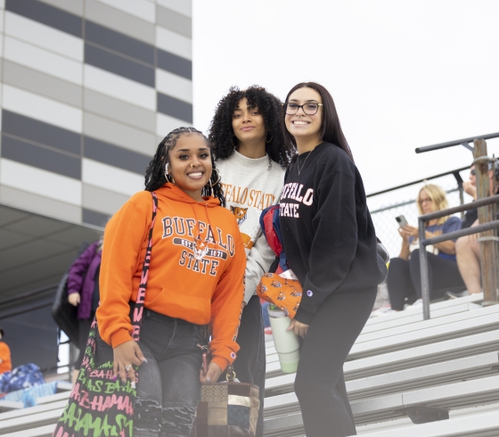 Three female students on bleachers