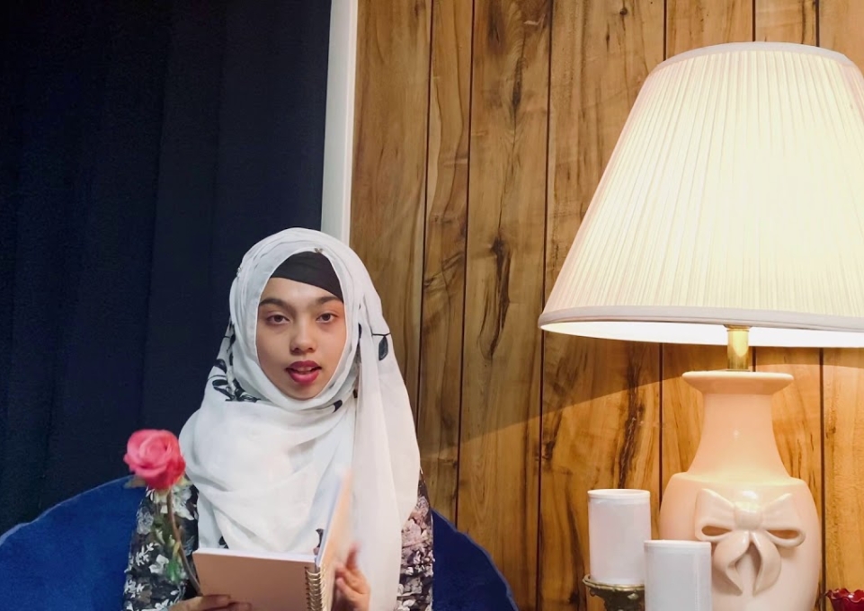 Student sitting on sofa reads from her work