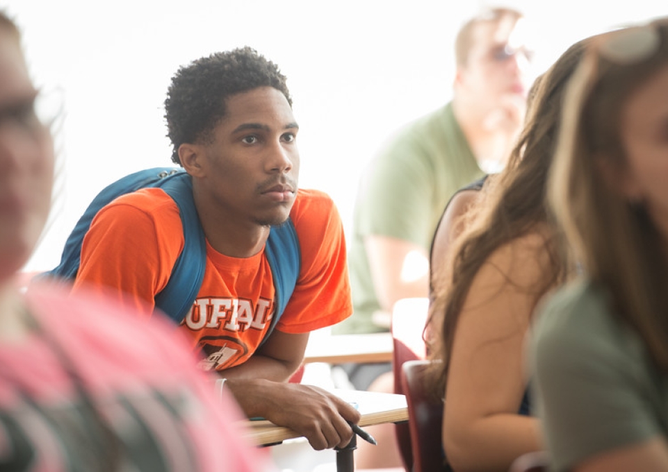 Seated male student listening intently