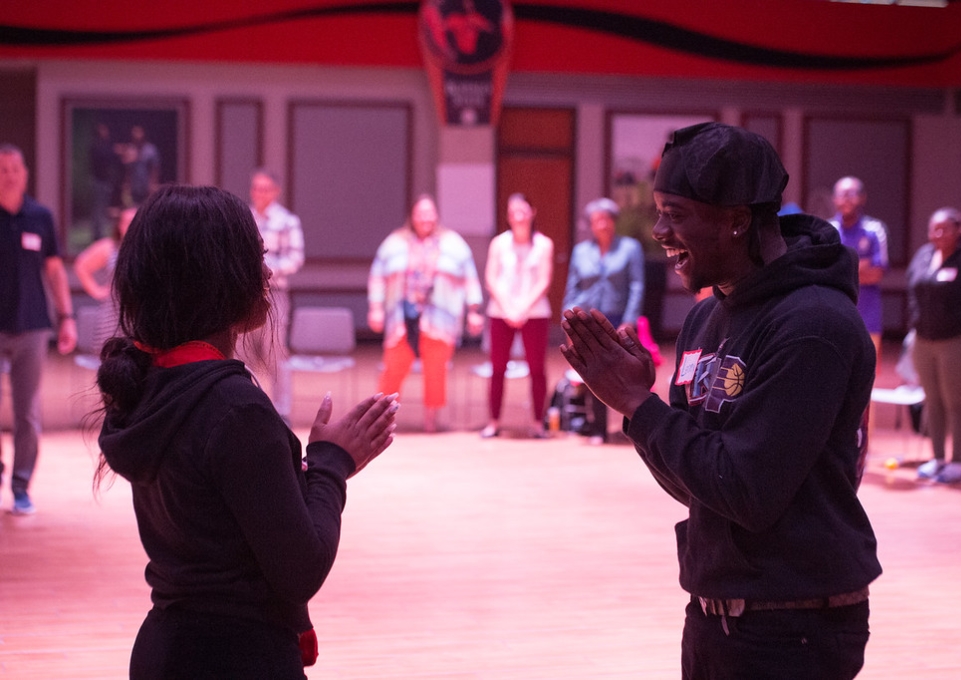 Two students from the RJ Circle face each other smiling