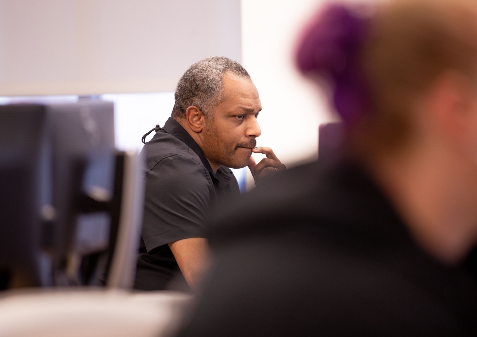 Man sitting at computer looking contemplative