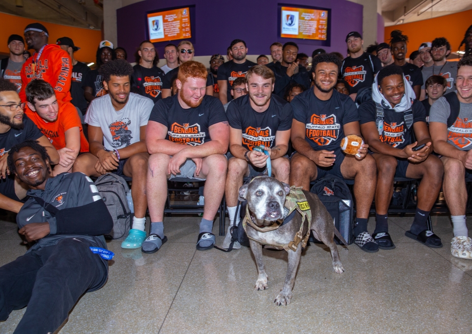 Buffalo State football players posing with Lloyd the dog