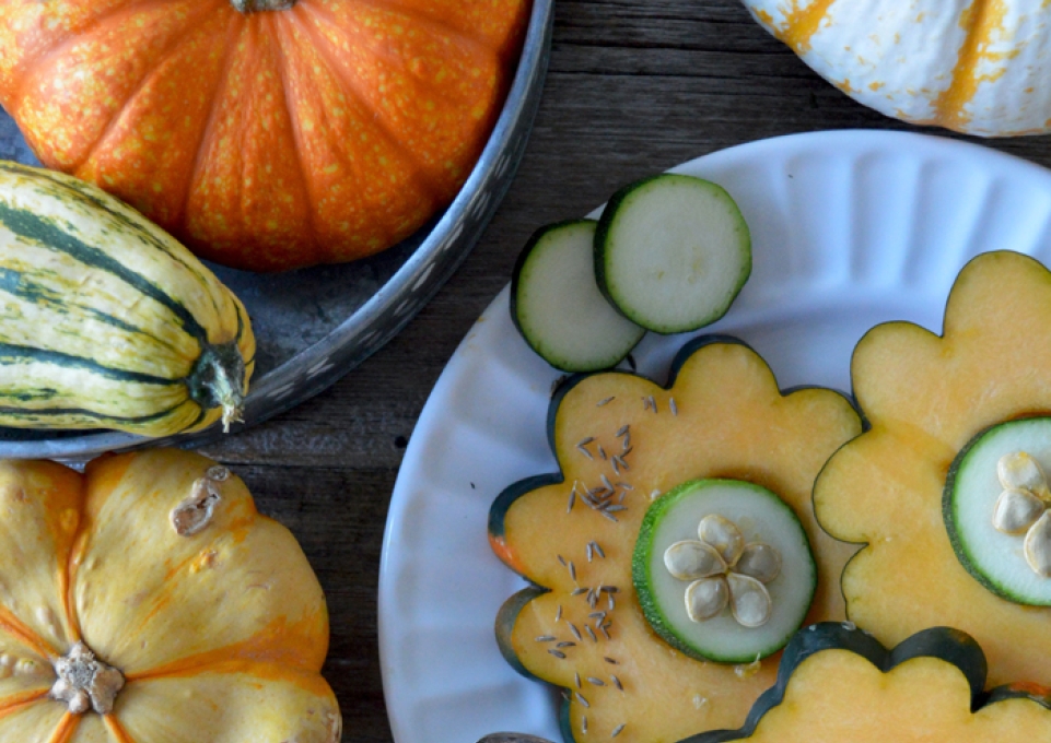 Squash and gourds, some cut in slices to look like flowers and arranged on a plate