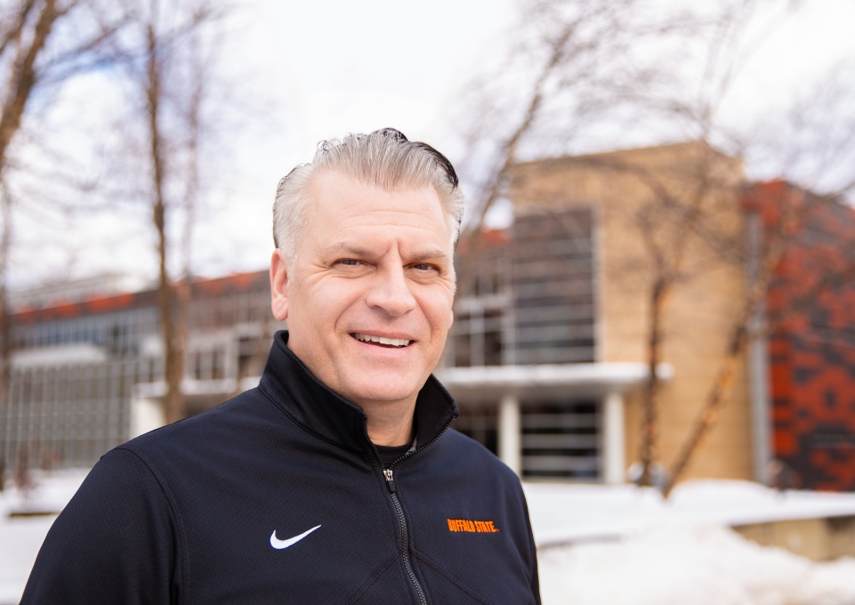 Tom Galluch standing outside in the snow in front of Caudell Hall