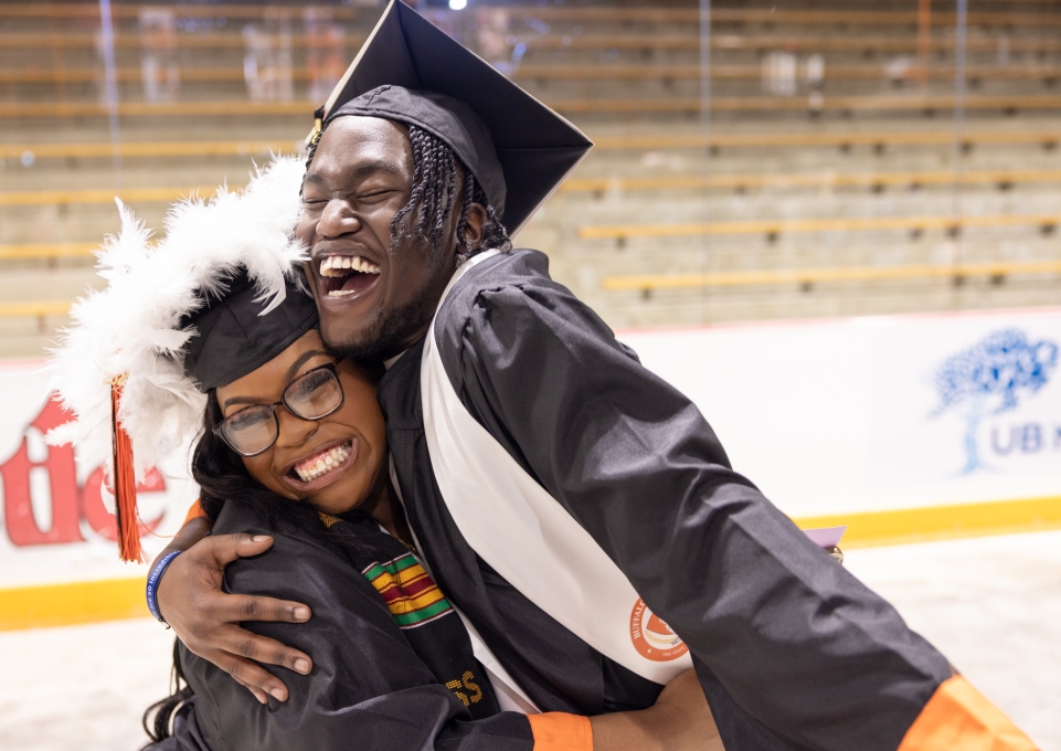 Two students hug at commencement