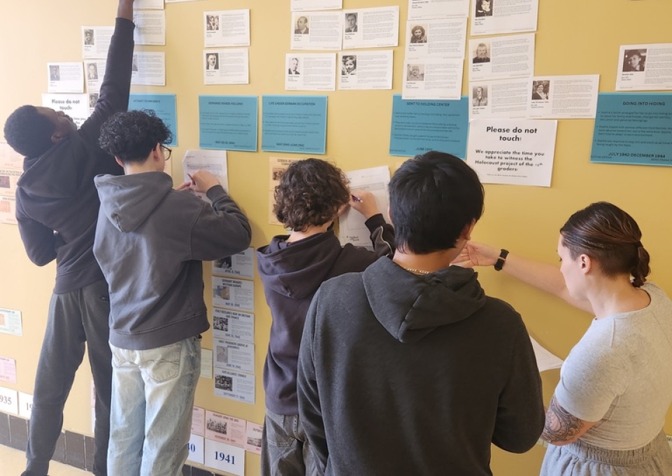 Children working on a wall display of a Holocaust timeline