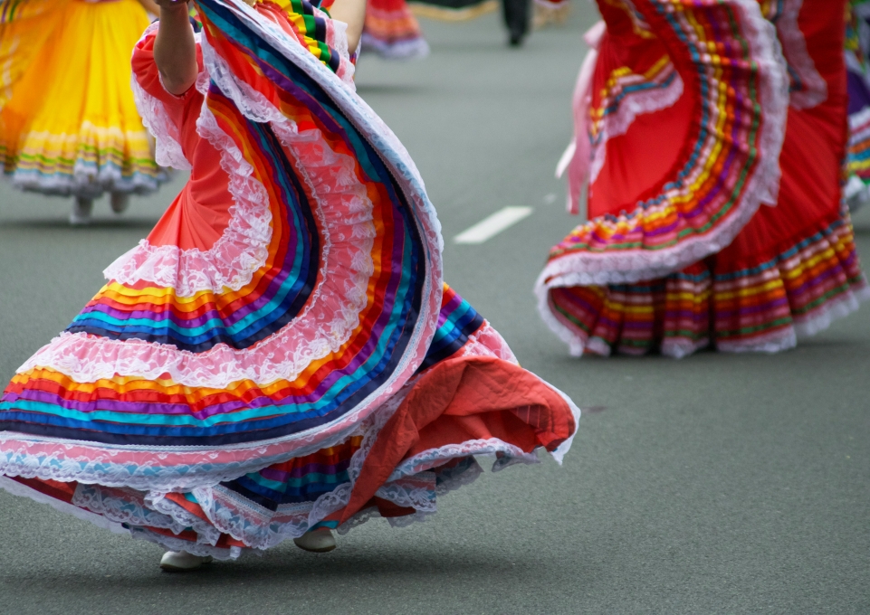 Women dancing in the street with colorful skirts