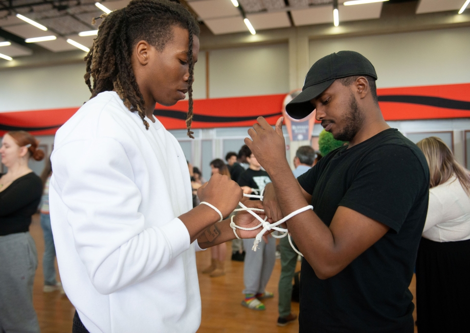 Two male students engaged in a human knot activity