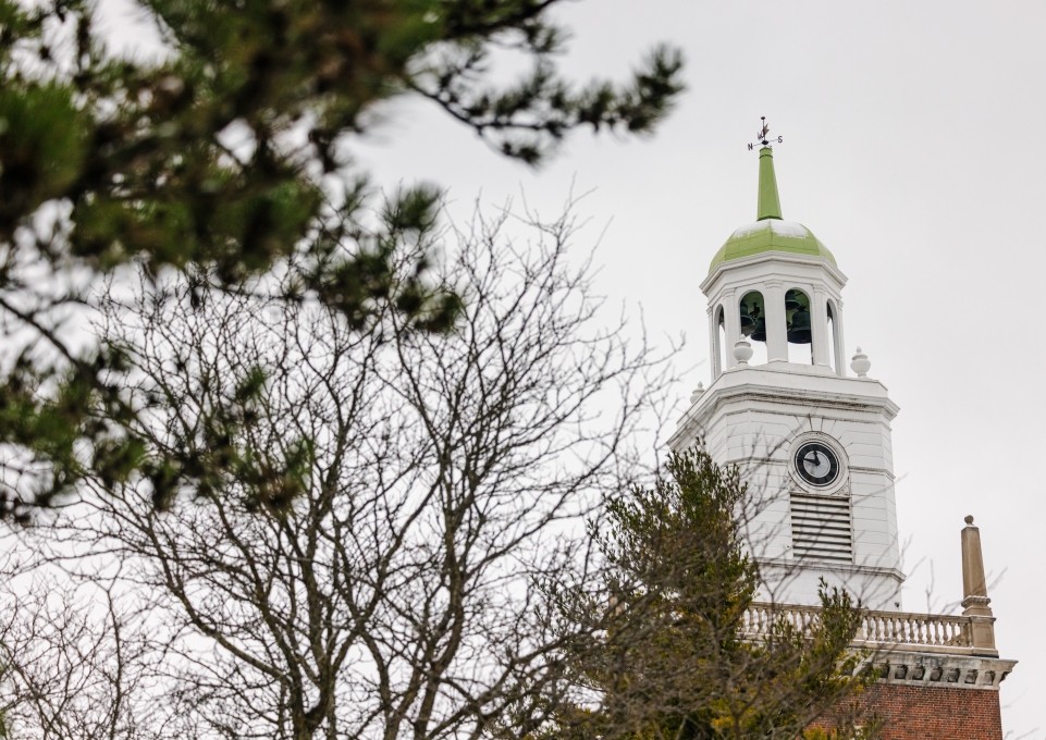 A view of the Rockwell Hall clocktower with a tree in front