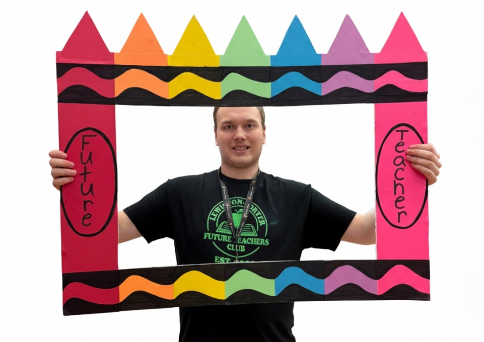 Male student holding a frame that says future teacher